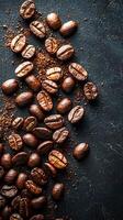 Roasted coffee beans and grounds cascade across a dark, textured surface, top-down view. photo