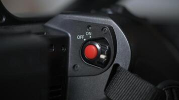 Red record button of black professional camcorder photo