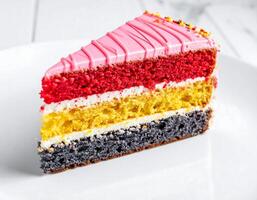 Slice of colorful layer cake with pink icing and sprinkles sitting on white plate photo