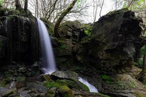 Waterfall cascading down mossy rocks photo