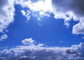 Bright blue sky framed by fluffy white and dark clouds. Inspiring, peaceful, and perfect for adding depth to design projects, websites, or marketing campaigns. photo