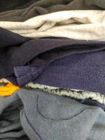 Abstract closeup of folded casual garments. Textiles in varying shades, perfect for backgrounds or illustrating texture, fabric or laundry concepts. photo
