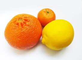 Vibrant citrus fruits a juicy orange, a mandarin, and a zesty lemon, arranged on a clean white background. This image conveys freshness, health, and the concept of variety. photo