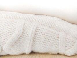 Cozy texture of soft, knitted woolen fabric in neutral tones. Ideal for backgrounds, promoting comfort, warmth, and relaxation. Evokes a sense of peace. photo