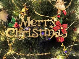 Close-up of a richly decorated Christmas tree, adorned with shimmering gold and pearl bead garlands, twinkling lights, and charming ornaments. photo