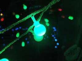 Vibrant teal and green fairy lights illuminate the dark background, creating a magical and festive atmosphere. photo