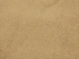 Fine golden sand a beach during a sunny day with clear skies, creating a serene and tranquil atmosphere for relaxation photo