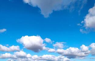 Vibrant blue sky dotted with fluffy white clouds. Represents freedom, peace, and opportunity. Perfect as a background, evoking calmness and optimism for your designs. photo
