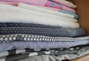 Children Wardrobe Shelf With Stacked Washed Bedclothes Closeup Angle View photo