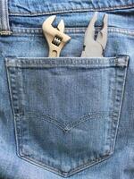 Sturdy Double Stitched Pocket To Hold Heavy Tools. Pliers And Adjustable Spanner Inside Denim Fabric Pocket Stock Photo For Vertical Story