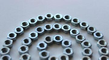 Segment Of Round Pattern Made With Same Diameter Shiny Steel Nuts Isolated On White photo