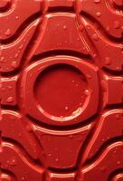 Water drops on a rad patterned plastic surface. Sock photo for abstract plastic backgrounds