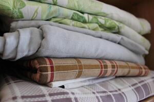 Home Wardrobe Shelf With Stacked Washed Bedclothes On It photo