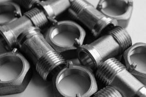 Set Of Dark Iron Piping Fittings And Plumbing Nuts Detailed Angle View. Pipe And Tube Cast Iron Connectors Isolated On White photo