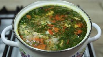 A fresh vegetable soup is gently simmering in a saucepan, releasing a savory aroma. Colorful ingredients blend together, creating a warm and nourishing homemade meal. video
