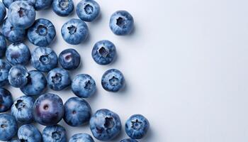Top view of scattered blueberries on white background with copy space for text photo