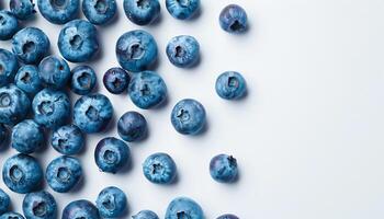 Fresh blueberries scattered on clean white background with empty space for text or branding top view photo