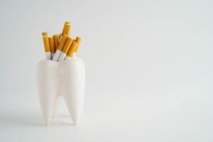 Cigarette with teeth isolated on white background, damage the health of your teeth, No smo photo