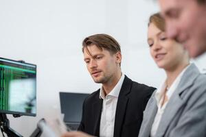 Team collaborates on digital project in modern office setting during work hours photo