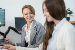Two women collaborating in a modern office environment while discussing a project during the afternoon photo