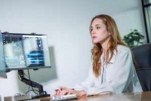 Focused data analyst working at a desk with multiple monitors in a bright office setting photo