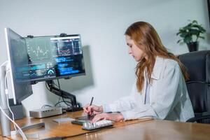 Young woman working on financial analysis at modern desk with multiple monitors and digital tools in a bright office environment photo