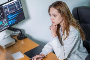 Young woman analyzing data on computer in modern office setting during daytime photo