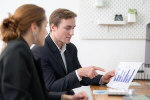 Business professionals discussing a financial report in a modern office setting during the afternoon photo