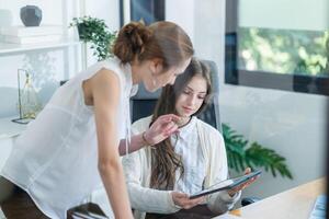 Collaborative meeting between two professionals discussing project ideas in a modern office setting during daylight hours photo