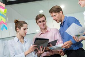 Team members collaborating on digital project in modern office environment during daytime photo