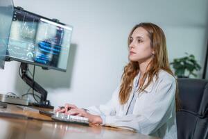 Young professional working at a computer desk in a modern office with multiple screens displaying data analytics photo