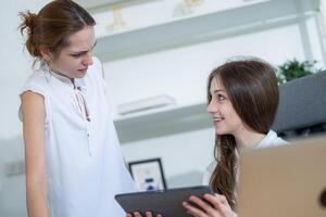 Two colleagues discussing a project indoors in a modern office environment during the afternoon photo