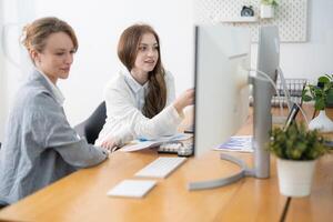 Collaboration during a brainstorming session in a modern office workspace with two women engaged in discussion photo