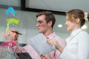 Team collaborates on project planning using sticky notes and a tablet in a modern office space photo