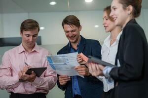 Team members collaborate on project details in modern office setting during afternoon meeting photo
