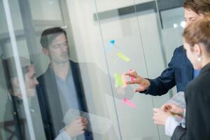 Team members collaborate in a modern office setting during a brainstorming session with colorful sticky notes photo