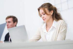 Focused professionals collaborating in a modern office setting with laptops and teamwork dynamics photo