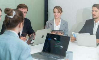 Business meeting with professionals discussing project updates in a modern office setting during daytime photo