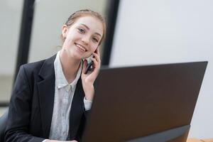 Young professional assisting clients remotely while smiling in a modern office environment during work hour photo