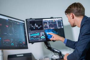 Professional analyzing data on multiple screens in a modern office setting photo