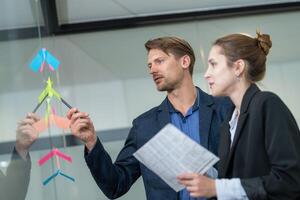 Team members collaborate on project planning using colorful sticky notes in a modern office setting photo