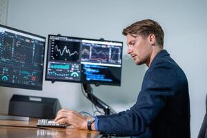 Professional trader analyzing financial data at workstation with multiple monitors during daytime photo