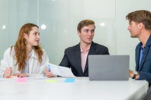 Team discussing project details in modern office setting during business meeting photo