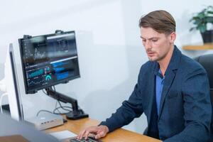 Professional man analyzing data on computer in a modern office setting during daytime photo
