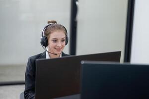 Young professional assisting clients remotely while smiling in a modern office environment during work hours photo