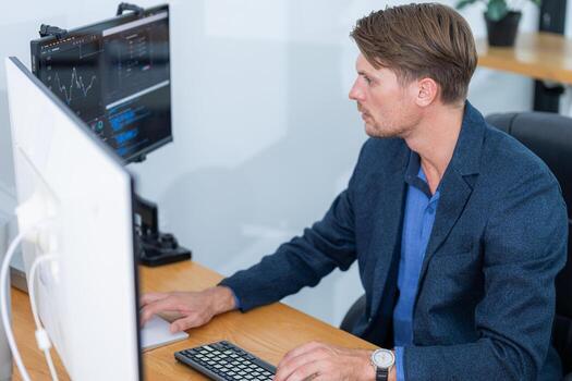 Business professional analyzing data on dual monitors in a modern office setting during the day photo