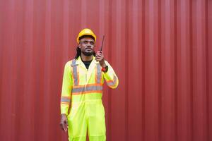 Engineer man in Safety Gear Inspecting Containers Box at Industrial Site, Container Yard Worker at Shipping Yard photo