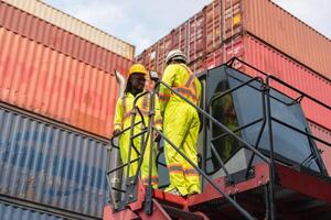 Supervisor in safety gear and engineer man in hardhat checking and control loading containers box from shipping yard, Workers collaborating at shipping container cargo photo