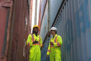 Engineer man Team in Safety Gear Inspecting Containers Boxes at Industrial Site, Container Yard Workers Discussion at Shipping Yard photo