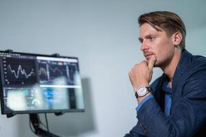 Professional man analyzing market trends on computer screen in modern office setting during work hours photo